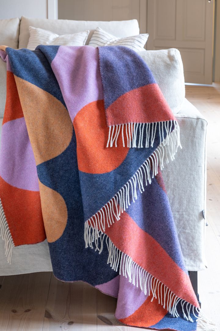 The interior design trends for spring 2023 offer colourful textiles and we like to decorate with the Wave throw from Stackelbergs in the colours blue, red, purple and apricot.