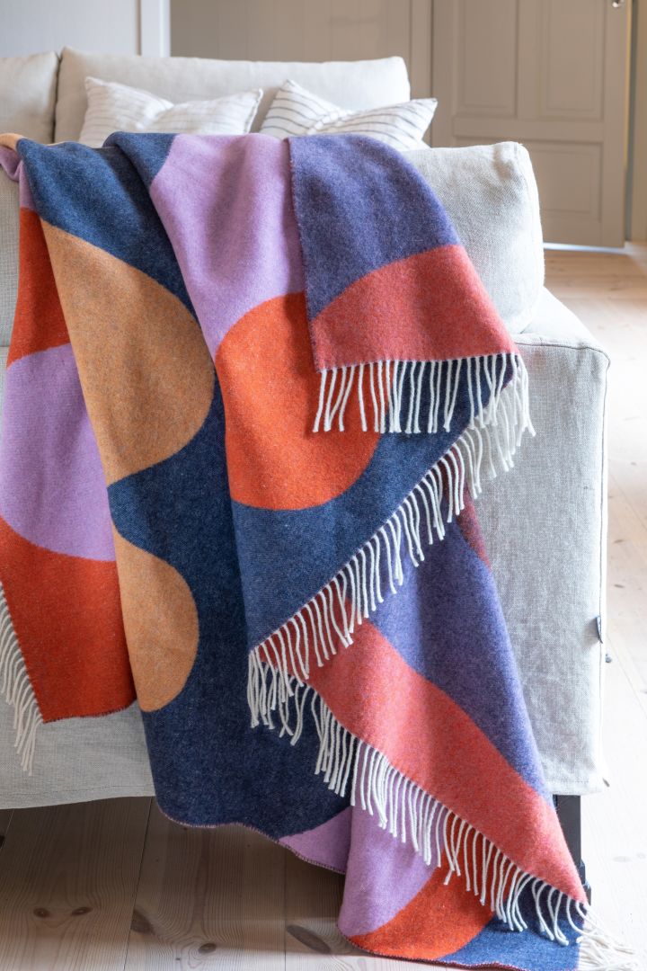 The interior design trends for spring 2023 offer colourful textiles and we like to decorate with the Wave throw from Stackelbergs in the colours blue, red, purple and apricot.