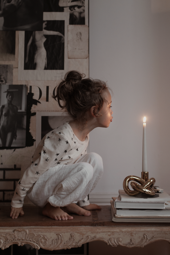 A boy blows out a candle in the Lykke One candle holder from Cooee Design. 
