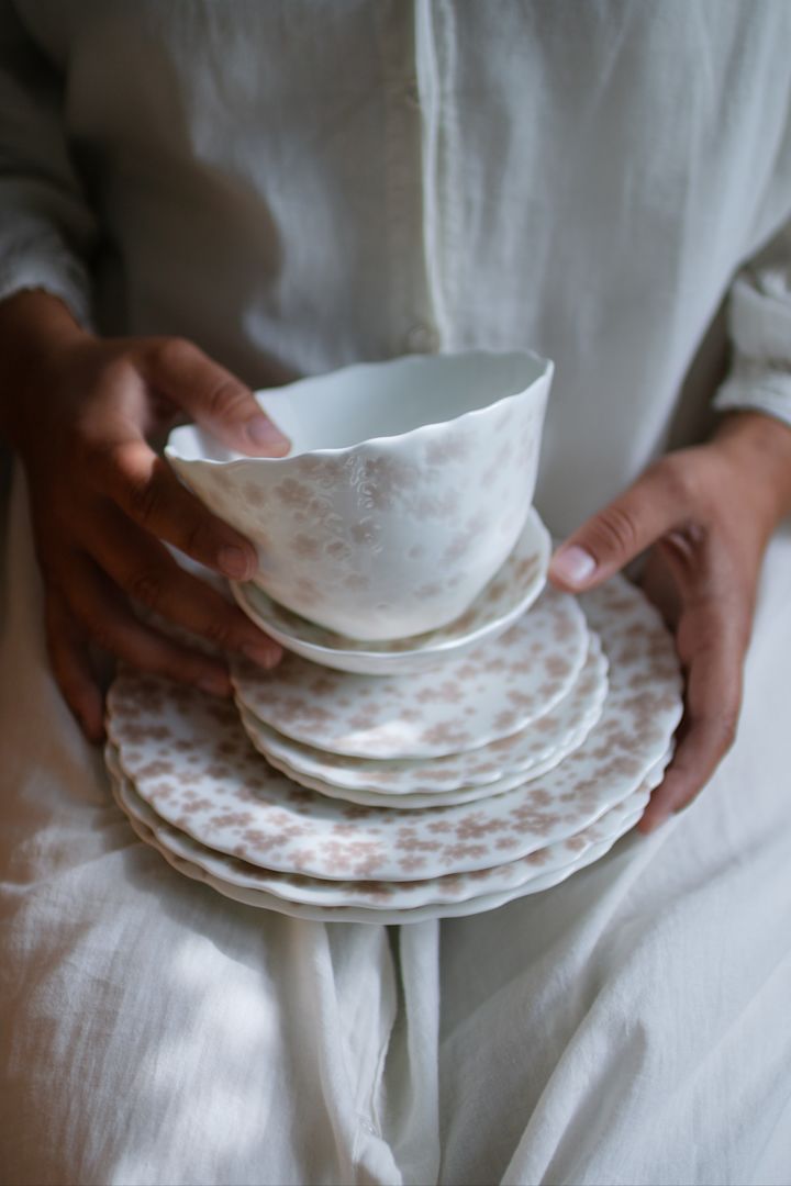 Here you see someone holding a stack of Slåpeblom plates from Wik & Walsøe.