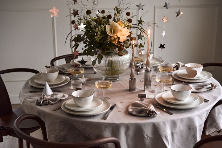 New year party ideas - a luxury white table setting with fluted glass elements that are reflected in the candle holders and place card holders from Georg Jensen. 