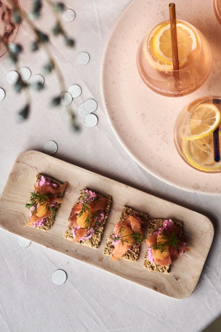 Salmon and beetroot canapes, one of the simple starter recipes for your New Year's party on the HK Living pink marble tray next to a champagne cocktail.