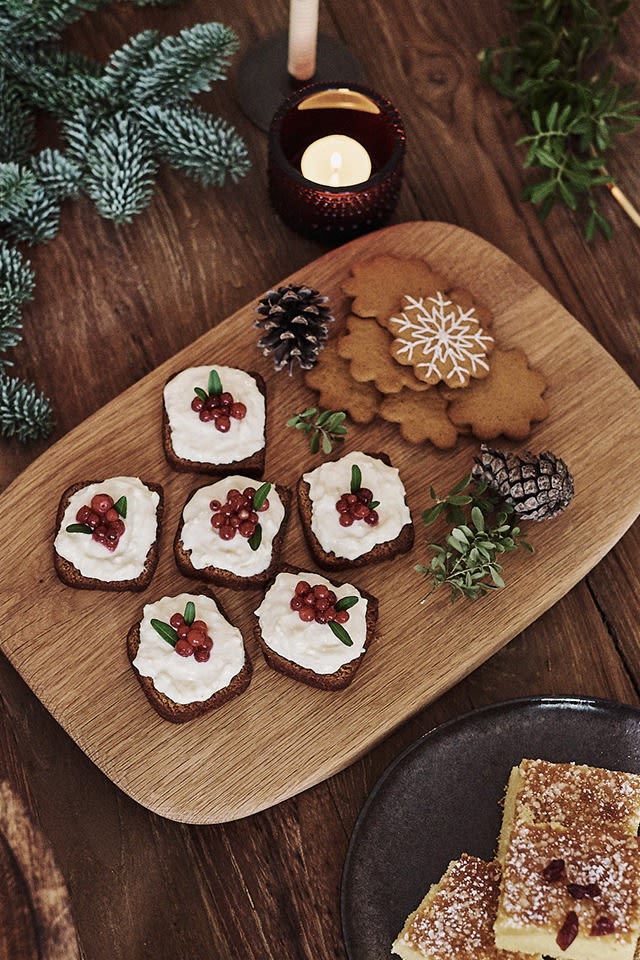 Soft gingerbread with frosting and decorated with lingonberries is served on the table on the morso Kit cutting board. 