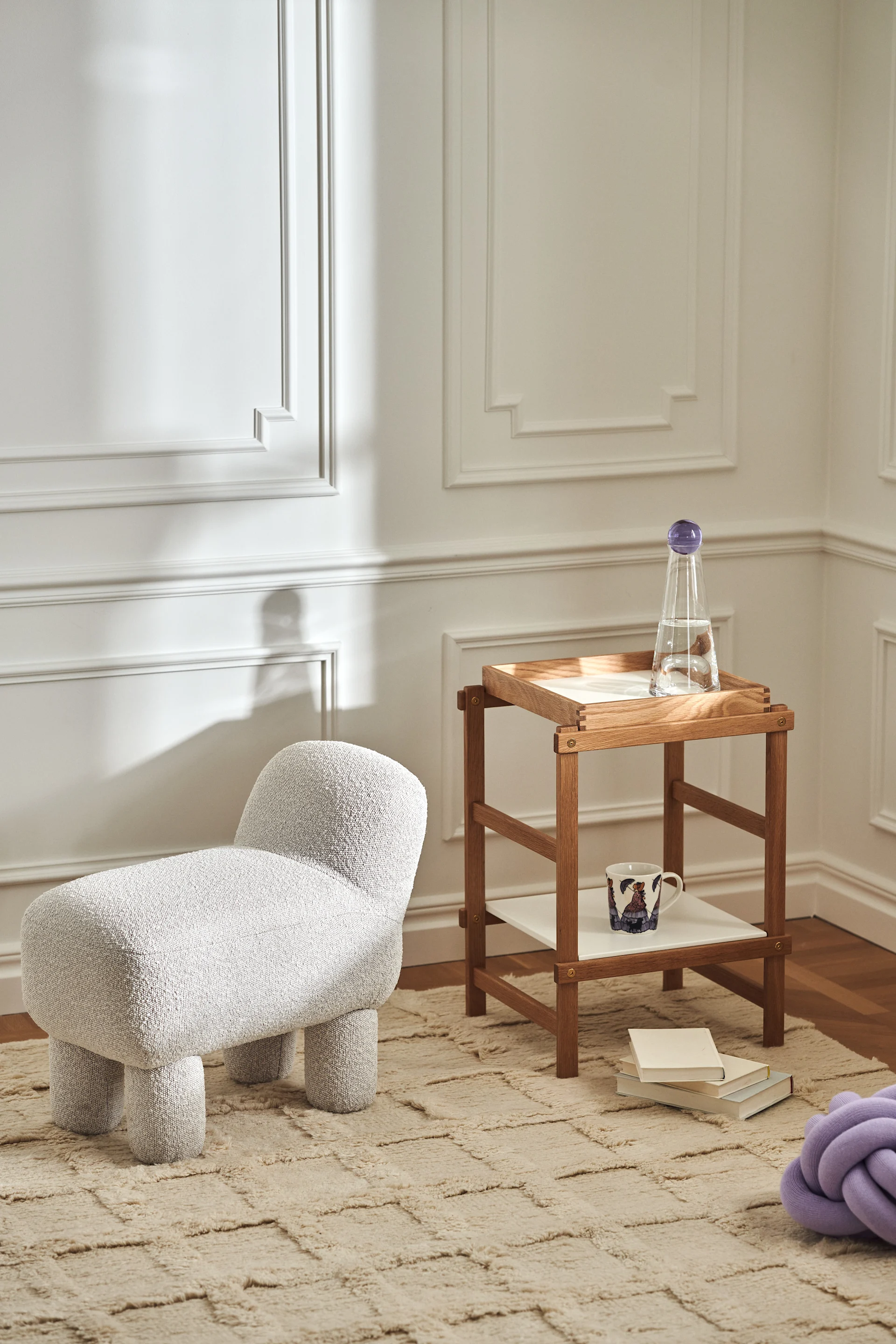 Stylish living room with products from Design House Stockholm in the form of Lulu pouf, Frame shelf in oak, Knot cushion in lavender and Elsa Beskow mug.