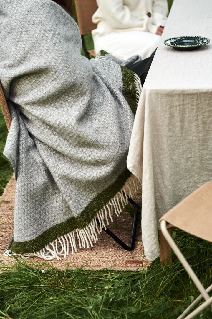 Discover our garden party inspiration - no garden party is complete without soft textiles to keep your guests warm here you see someone wrapped in the Hampus wool throw from Klippan Yllefabrik. 