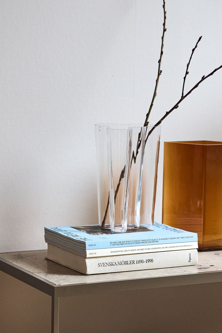 The clear Aalto vase stands on a stack of magazines.