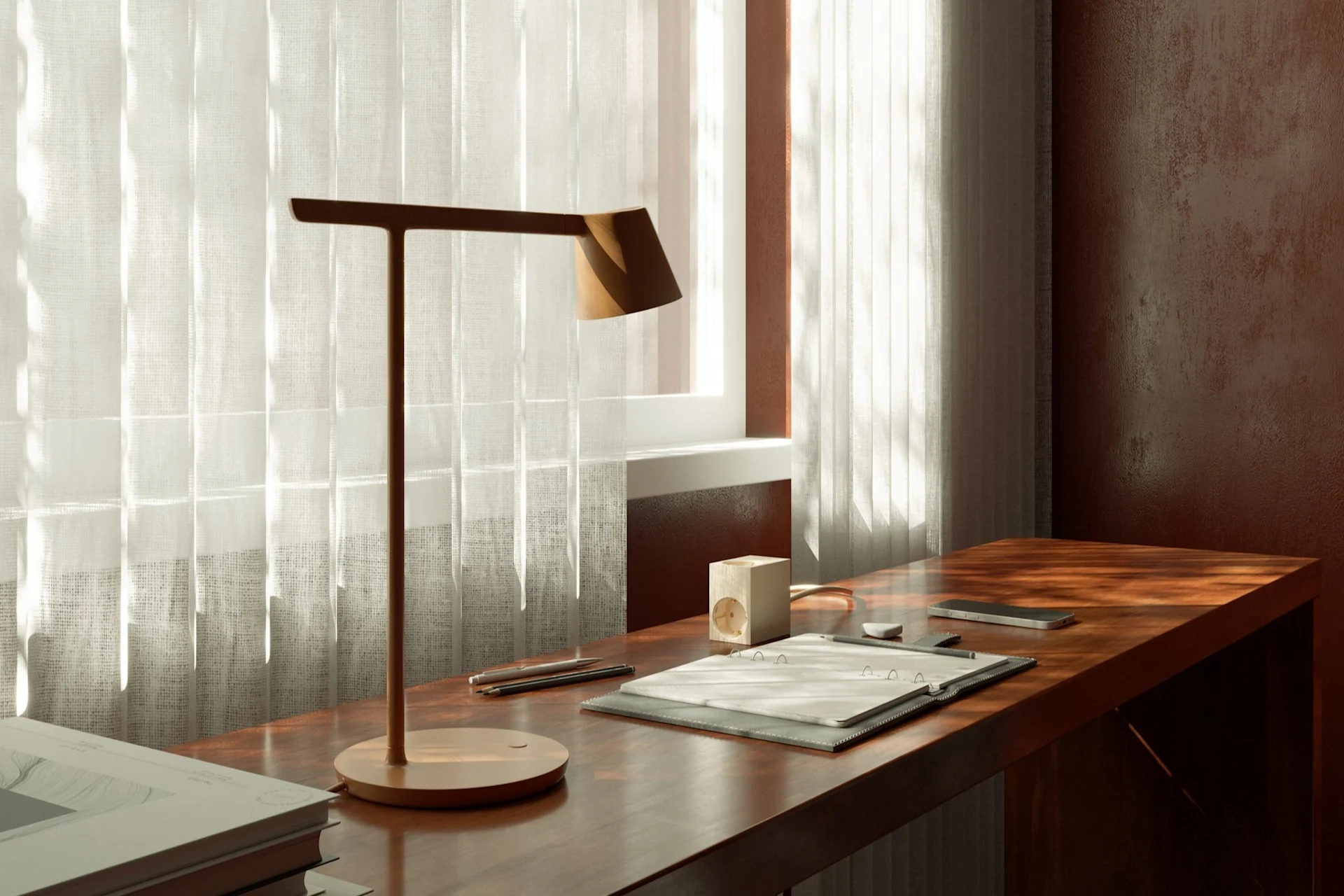 A workspace with a modern desk lamp, notepad, and smartphone on a wooden desk by a window with sheer curtains.