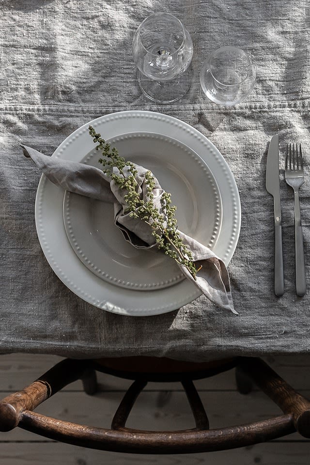 Napkin folding ideas - Linen napkin in the colour sand from Nordic Nest in a knotted napkin fold, here decorated with a flower.