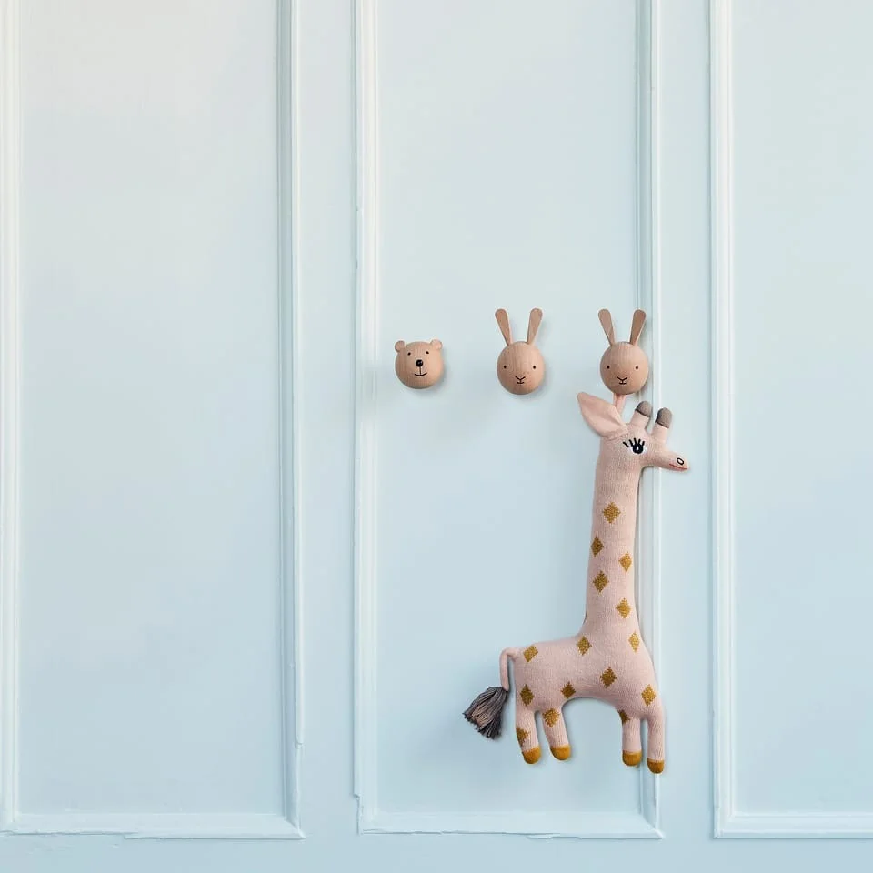 Here you can see the mini wall hooks in the shape of a bear and rabbit from OYOY with the Baby Guggi Giraffe, also from OYOY - practical baby shower gift ideas. 