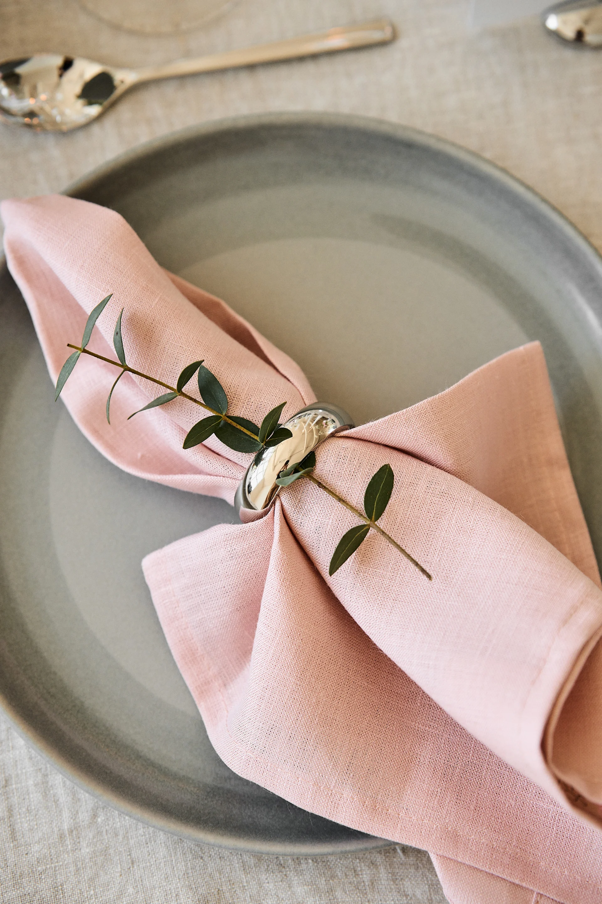 Decorate the table for your romantic meal at home in pleasant colours. Here you can see the Clean napkin in Dusty Rose from Scandi Living lying on a plate with a napkin ring.