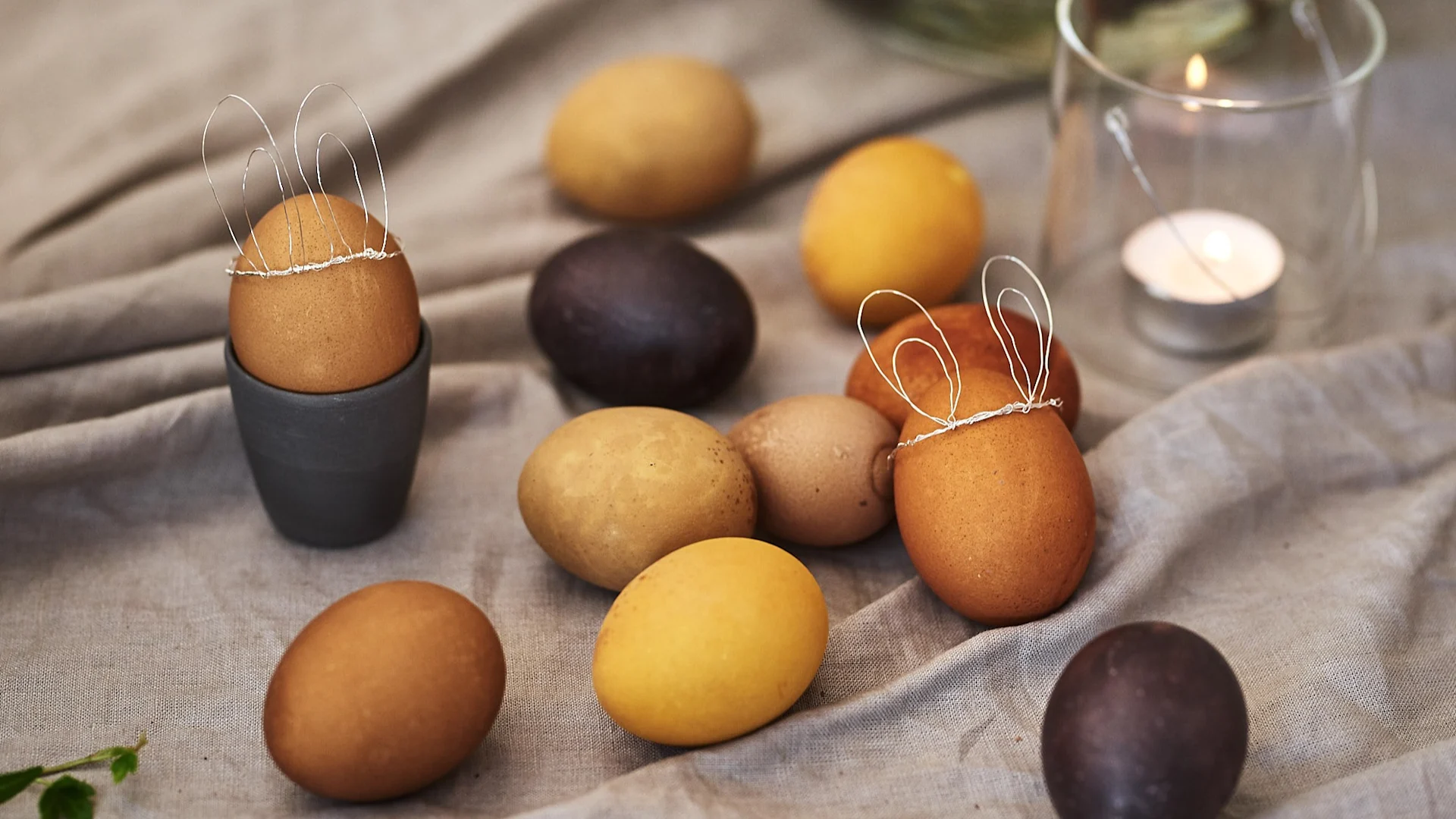 Dye eggs naturally with ingredients such as turmeric and coffee for Easter eggs in subtle shades of yellow and brown and make cute bunny ears out of wire for decoration.