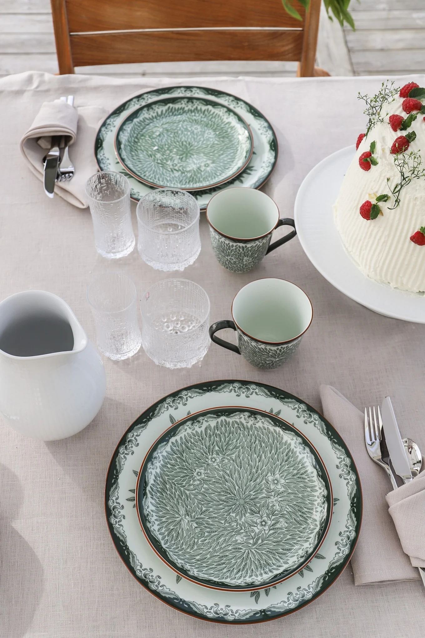 Traditional midsummer party ideas include alfresco dining. Here you see the green Ostindia and Ostindia Floris series on the table with the ultima thule glasses from Iittala. 