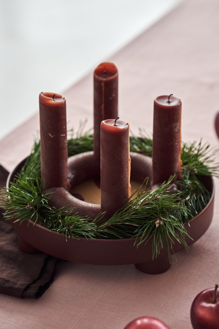 Create a centrepiece for your Christmas tablescape using a tray, a round advent candle and some sprigs of green fir. 