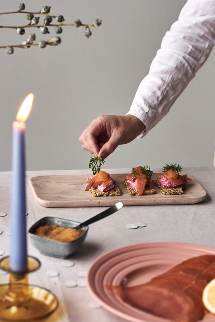 Placing dill on top of a salmon and beetroot canape, one of the four simple starter recipes we have for you this new year.