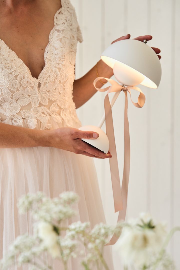 Here you see a bride holding a white VP9 Flowerpot portable table lamp. Be sure to include a gift table when planning your wedding. 