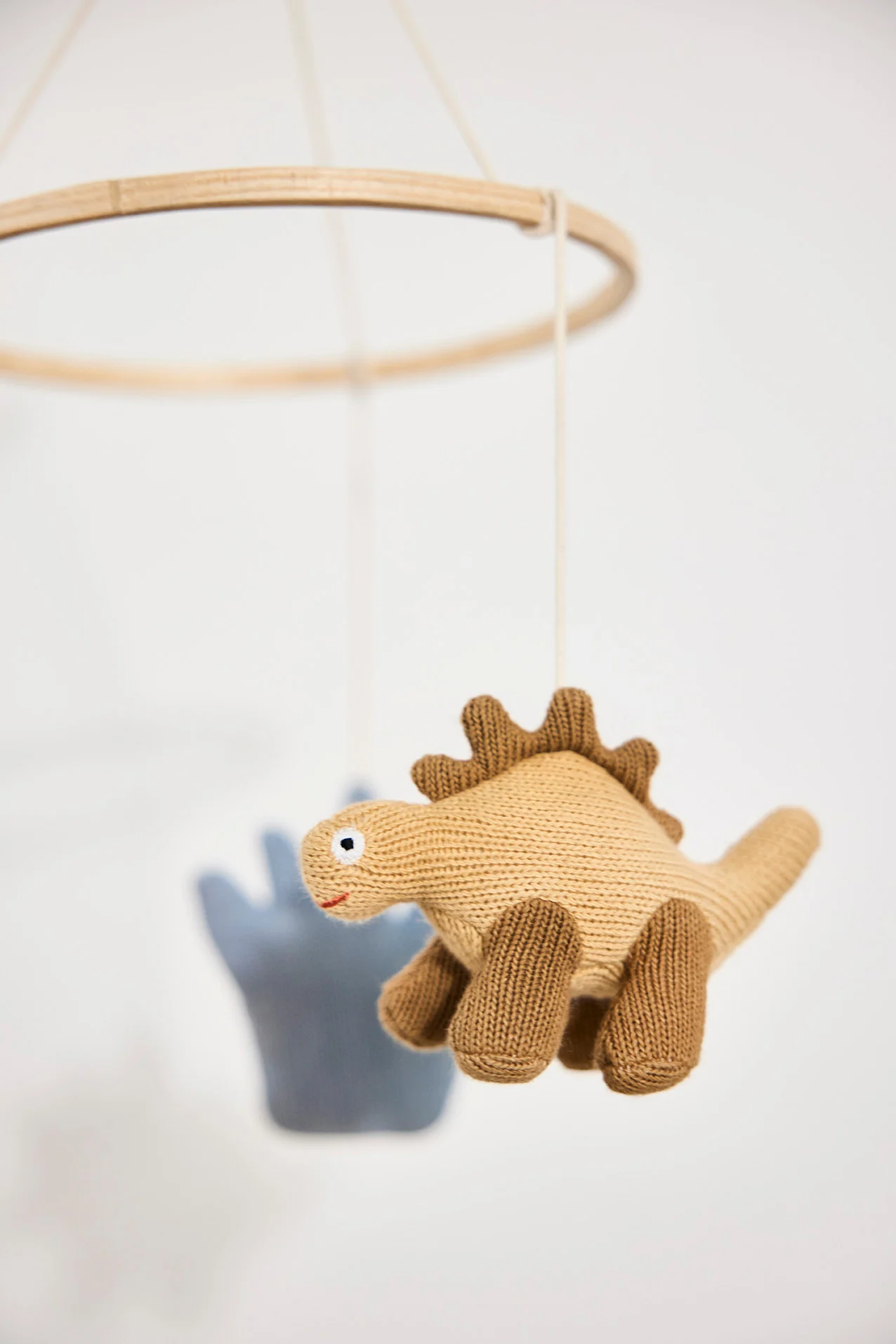 An image of a baby's nursery with a mobile hanging over a cot and a floor gym on the floor. Mobiles make perfect baby shower gift ideas. 