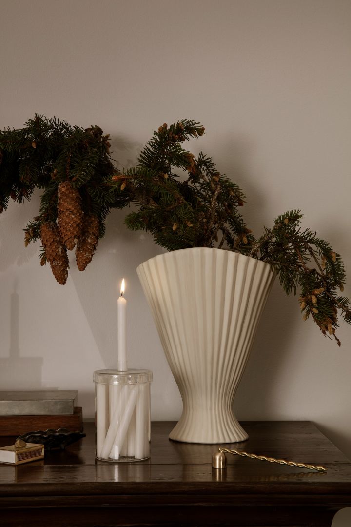 Advent candles in a beautiful jar from Ferm Living together with a tall, white vase for fir branches are right on trend for the Scandi Christmas decorations for 2022. 