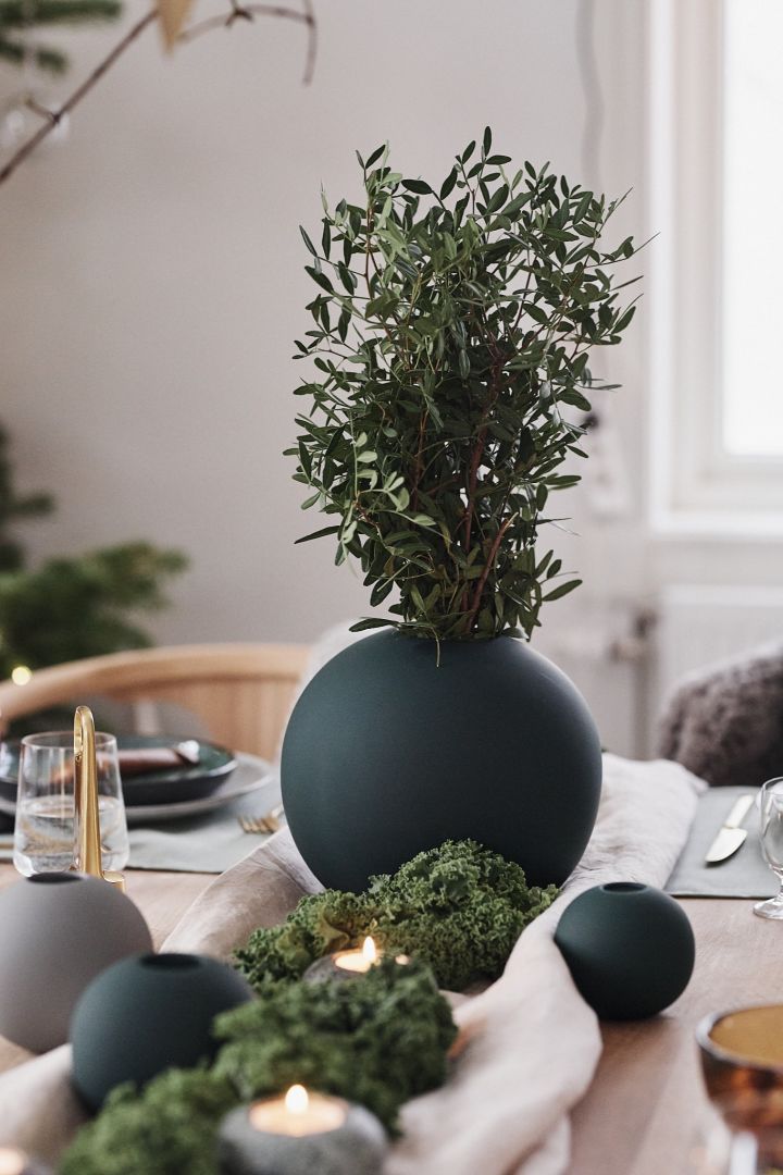 The green round vase by Cooee Design adorns the Christmas table decorations in shades of green with inspirations from nature.