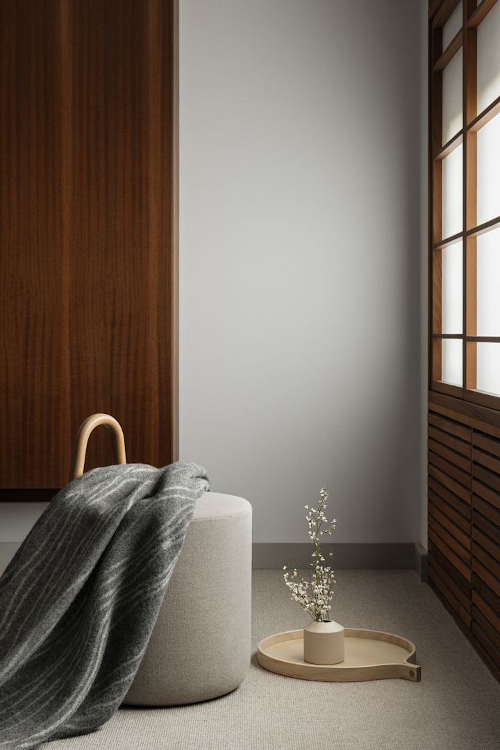 Here you see the Amstelle pouf with handle in natural ash from the Swedish brand Swedese.