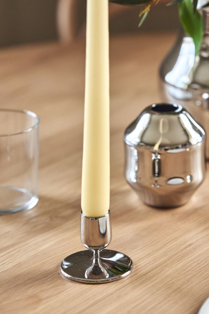 A close up of the short Dorotea candlestick in polished stainless-steel for Gense. 