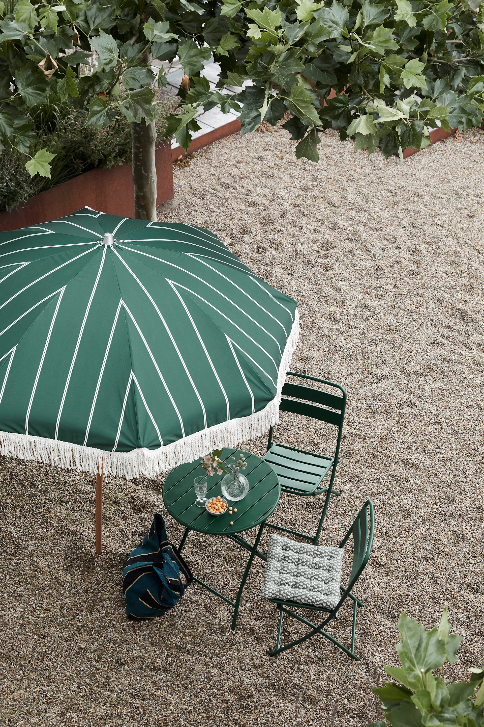 It is a great idea to have a parasol on the balcony here you see the Block parasol in green with a fringed edge from House Doctor. A smaller parasol suitable for a balcony or small patio.