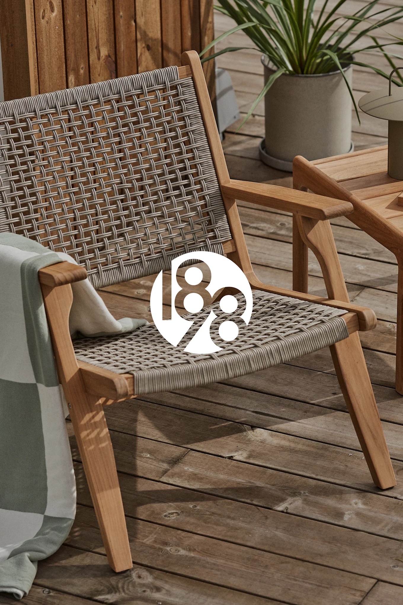 Outdoor wooden lounge chair with woven seat and back, a green and white blanket, on a deck. A white circle with "188" is overlaid.