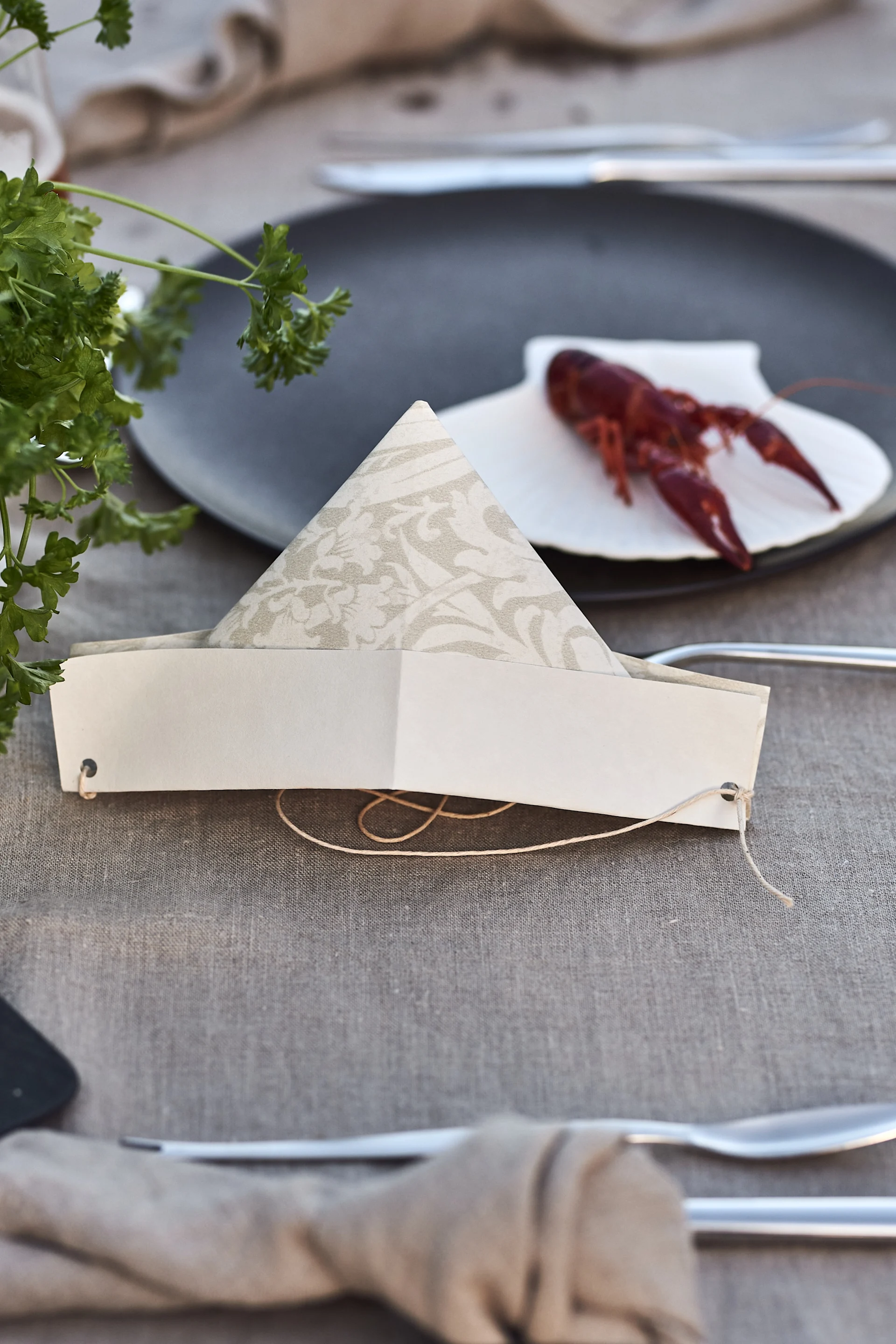 A completed paper hat folded from old wallpaper for a crayfish party.