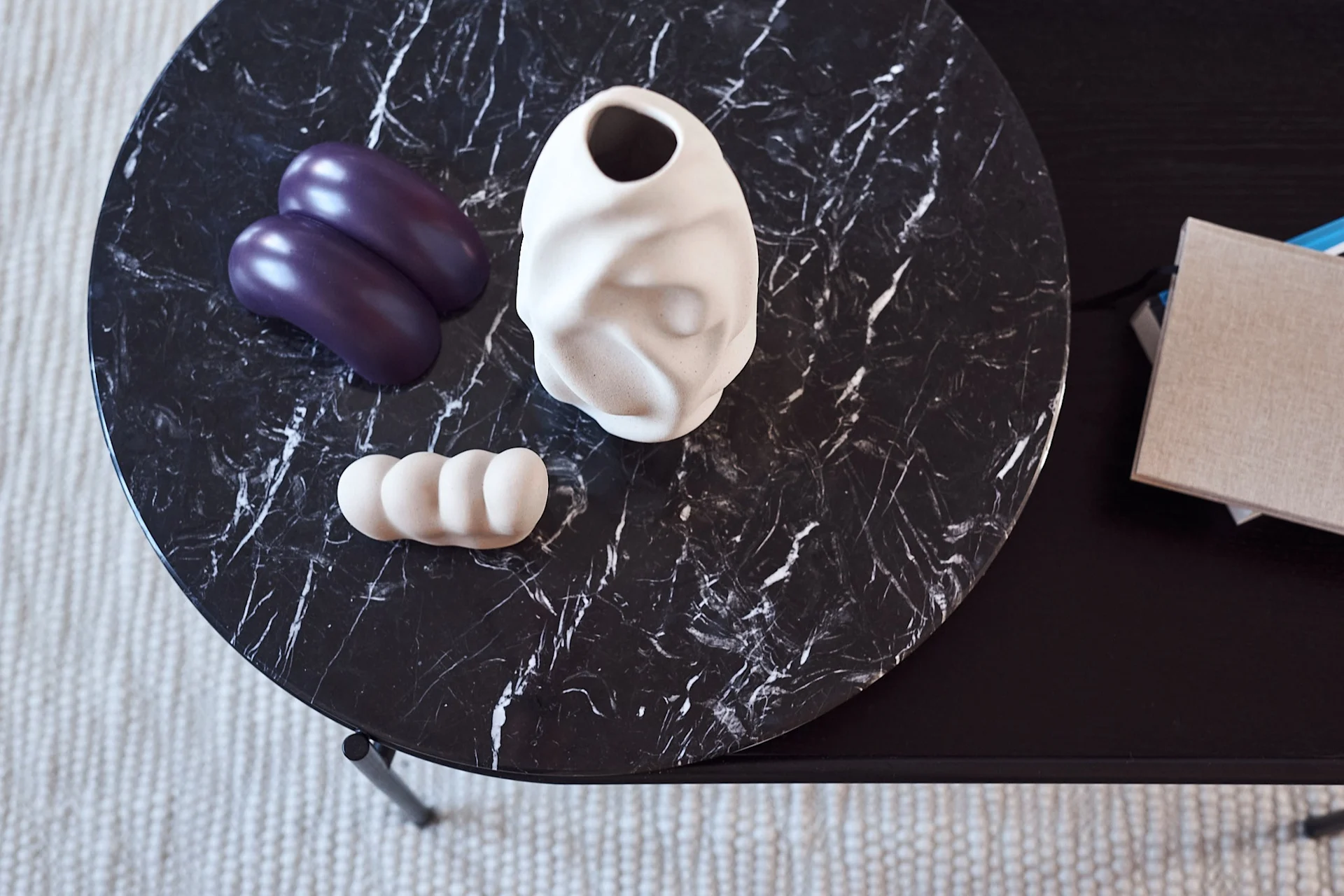 Mix of interior details such as vase and door stops from Hay on a marble table.