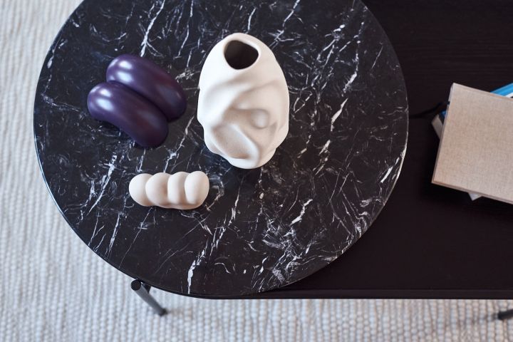 Mix of interior details such as vase and door stops from Hay on a marble table. 
