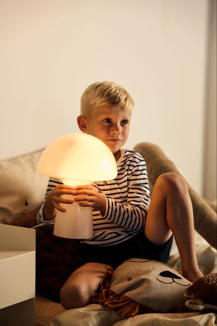 Choose the right light bulb - a young boy holds a glowing mushroom shaped lamp.