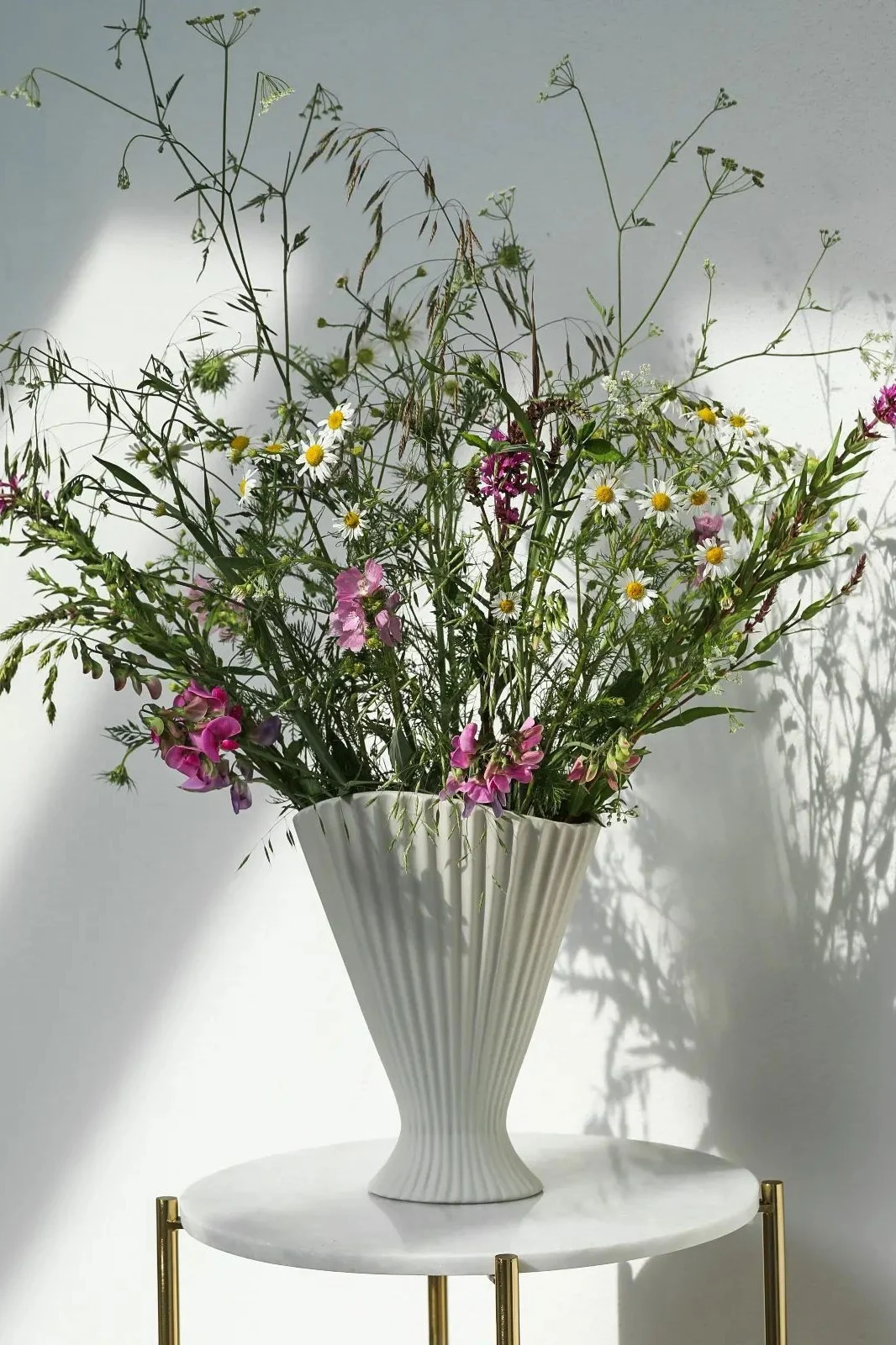 The best vase for long stemmed flowers, here you see a tall vase with black and white stripes filled with sunflowers. 