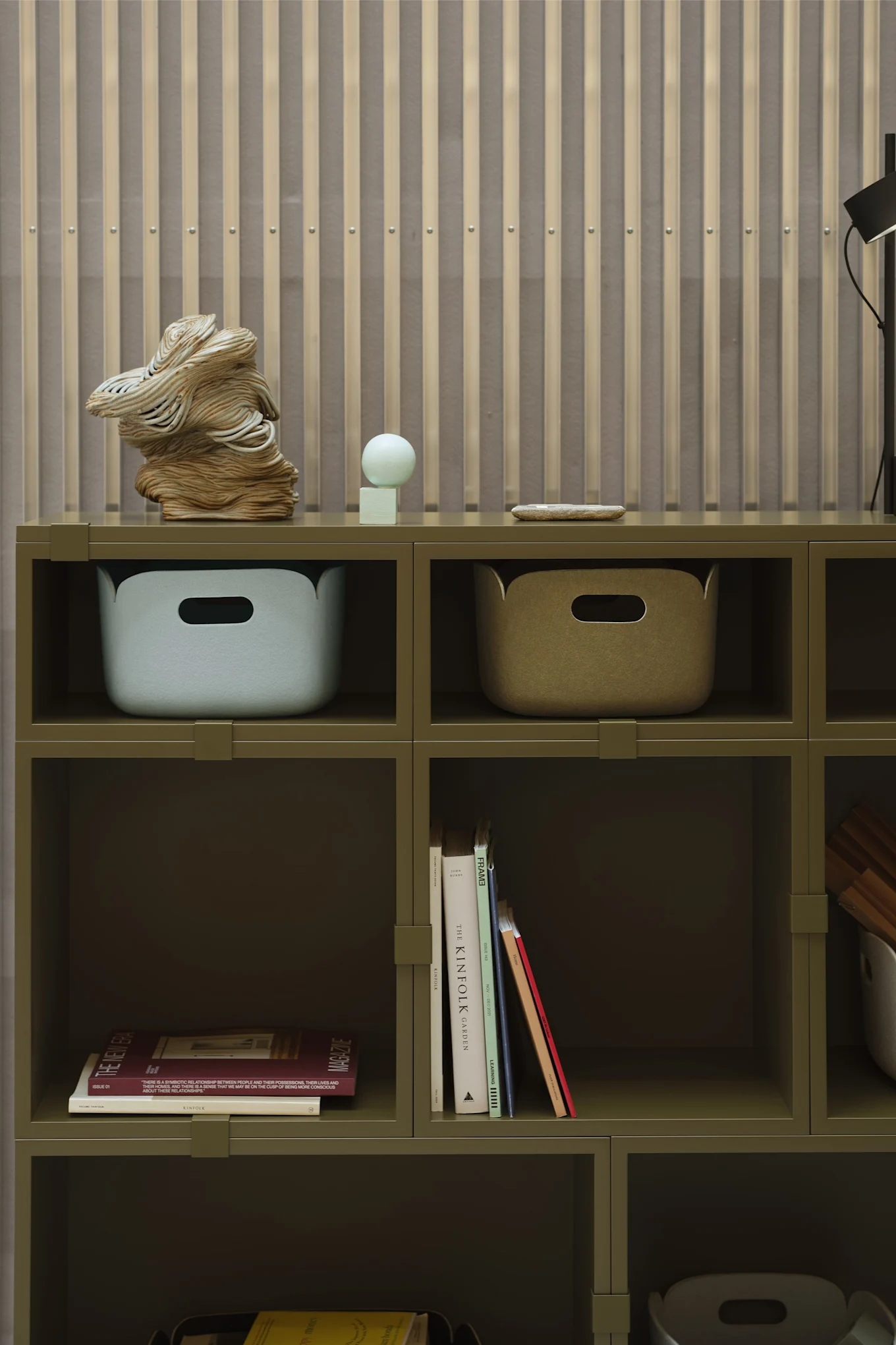 A green shelf with restore boxes and books as decorative details, in line with the interior design trends of 2026.