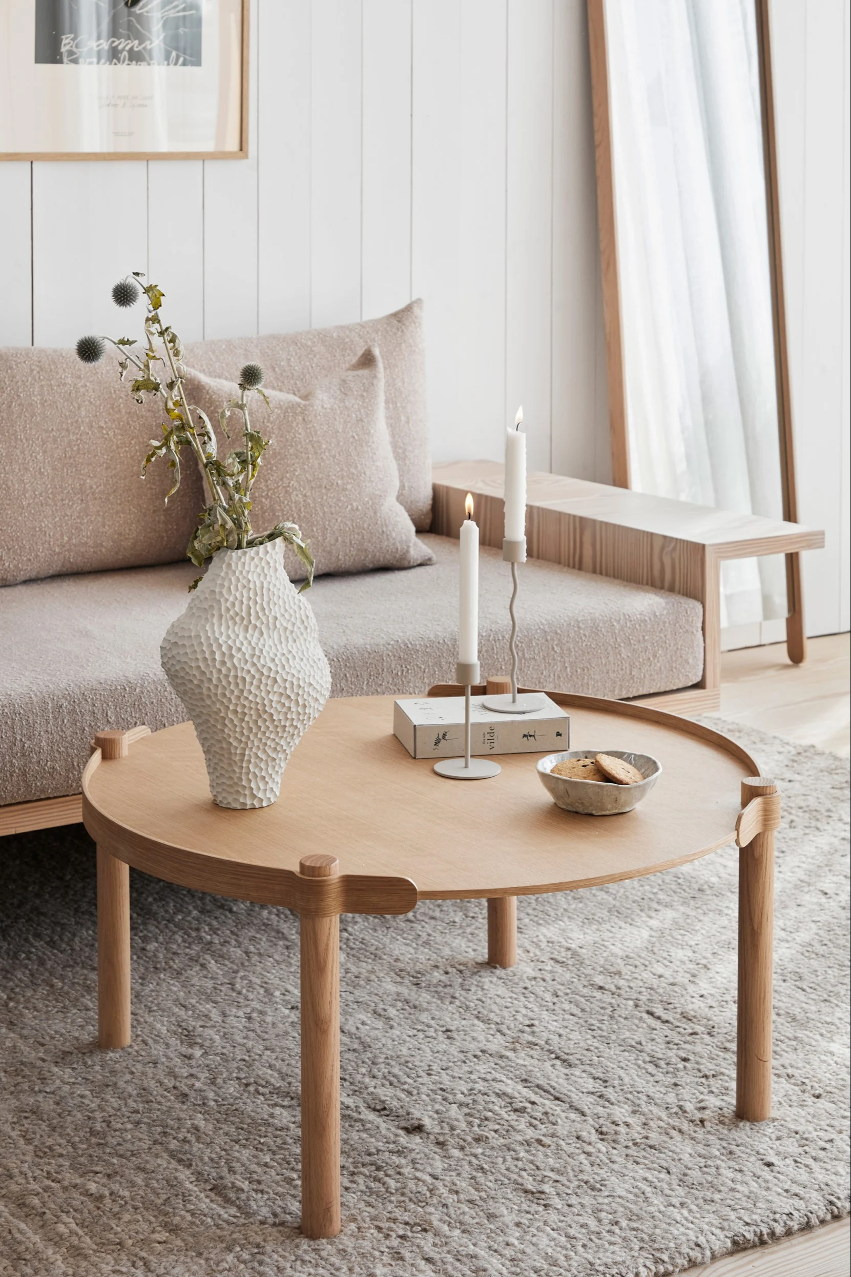 A cream-coloured Scandinavian living room with products from Cooee Design’s range including the Woody coffee table, the Isla vase and the Curve candle holder.