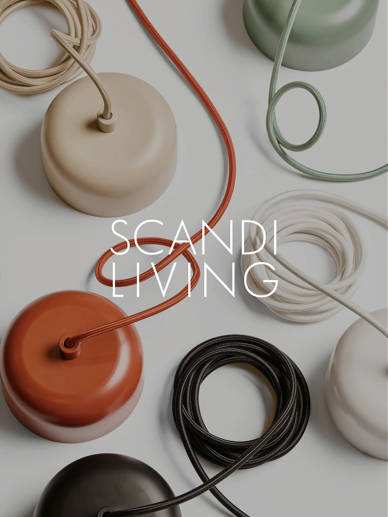 SCANDI LIVING text on a flat lay of colorful domed ceiling rose covers and coiled fabric cables.