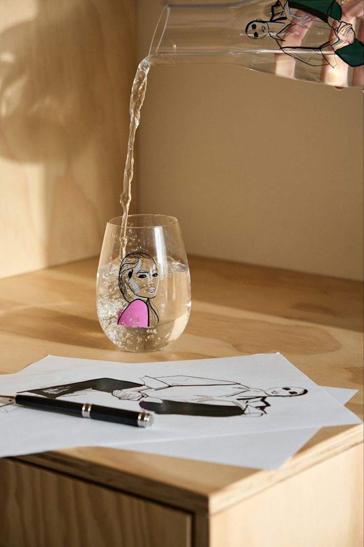 Water is poured from the Time for you carafe into the Next to you drinking glass, both from the All about you collection. 