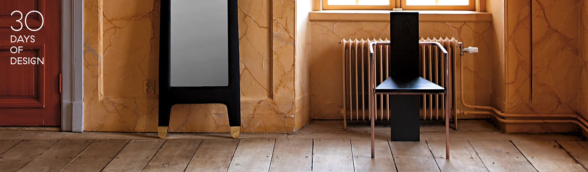 Modern black chair with copper legs, tall dark mirror with gold feet, in a room with textured walls. Text: 30 DAYS OF DESIGN.