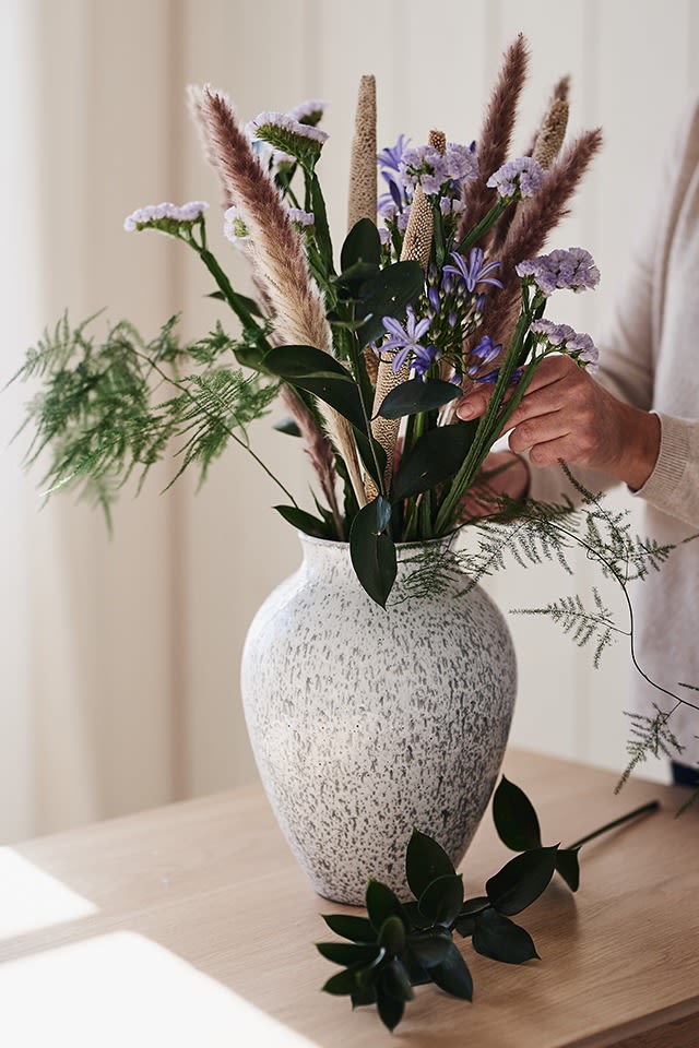 The tall white vase in ceramic from Knabstrup stands on the table with cut flowers from Blombruket. 