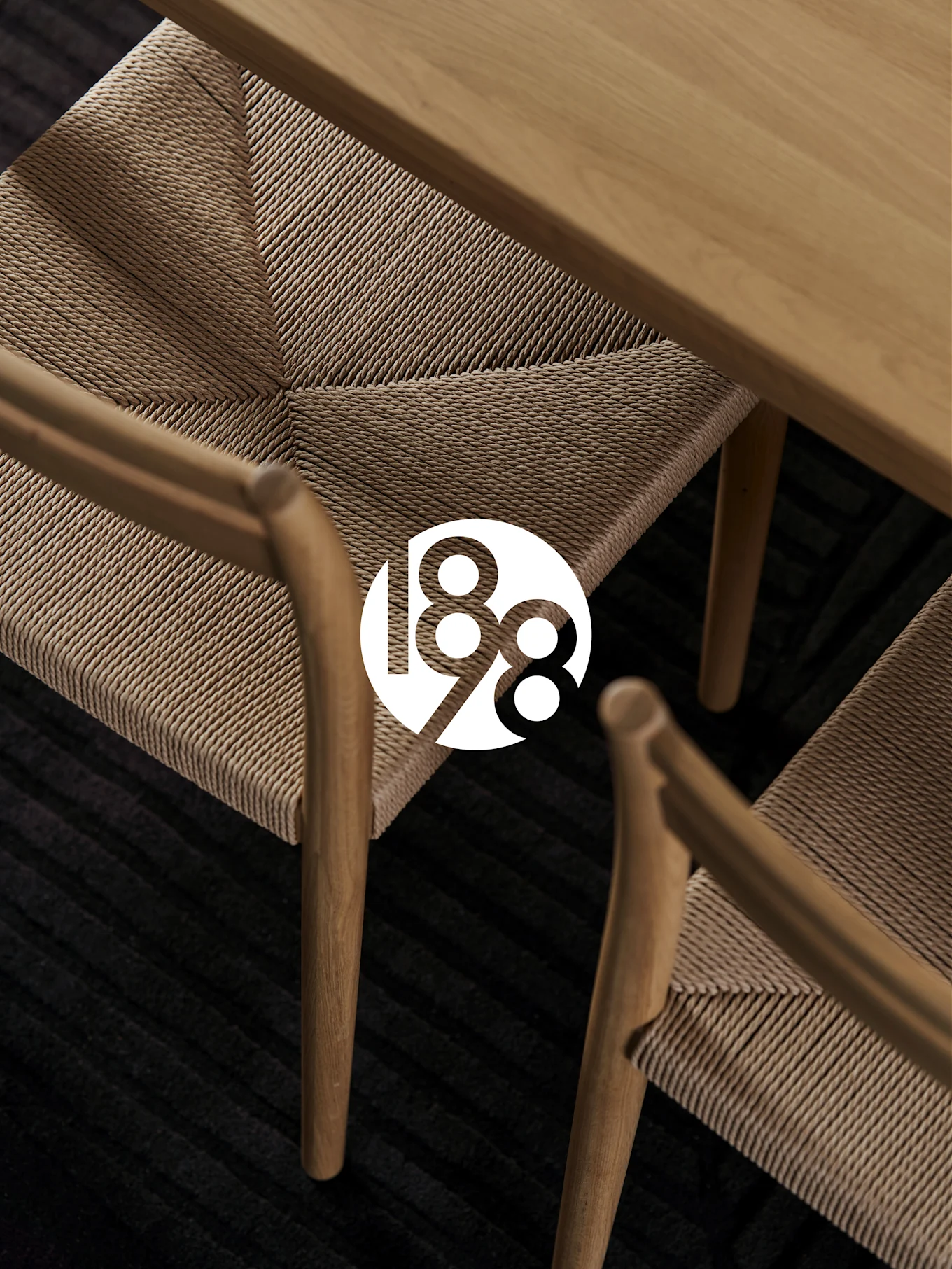 Two wooden chairs with woven seats, a wooden table, and a dark rug. White '188' logo overlay.