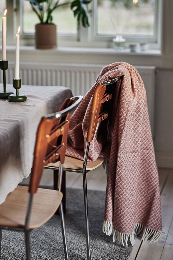 The dusty pink wool throw from Scandi Living rests over a dining room chair creating a cosy dining area. 