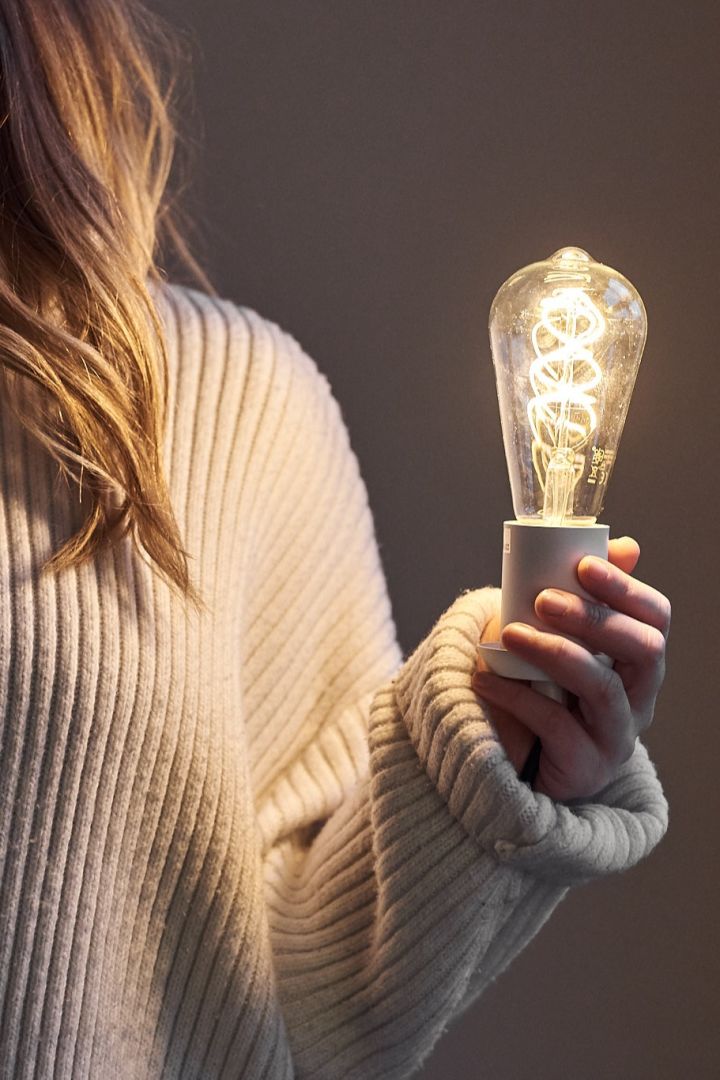 A light bulb in the hand of a woman.