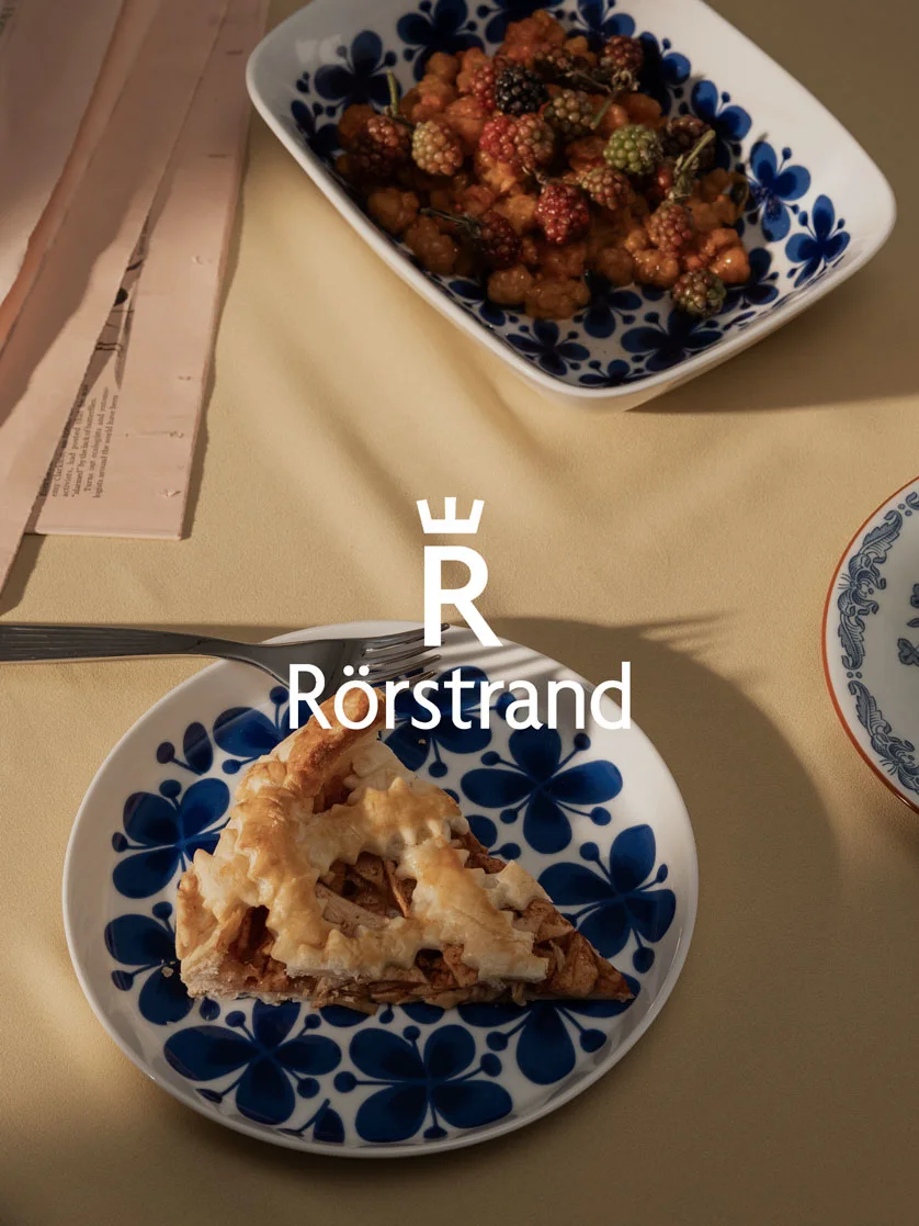Slice of apple pie and berry dessert on blue floral patterned Rörstrand dishes.