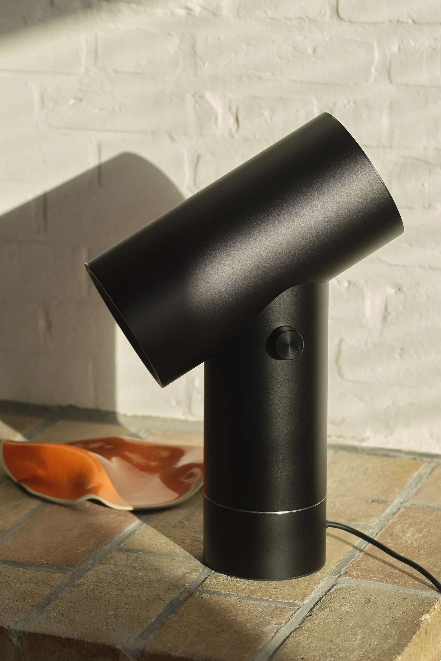 The black Beam table lamp from Muuto in a tiled setting.