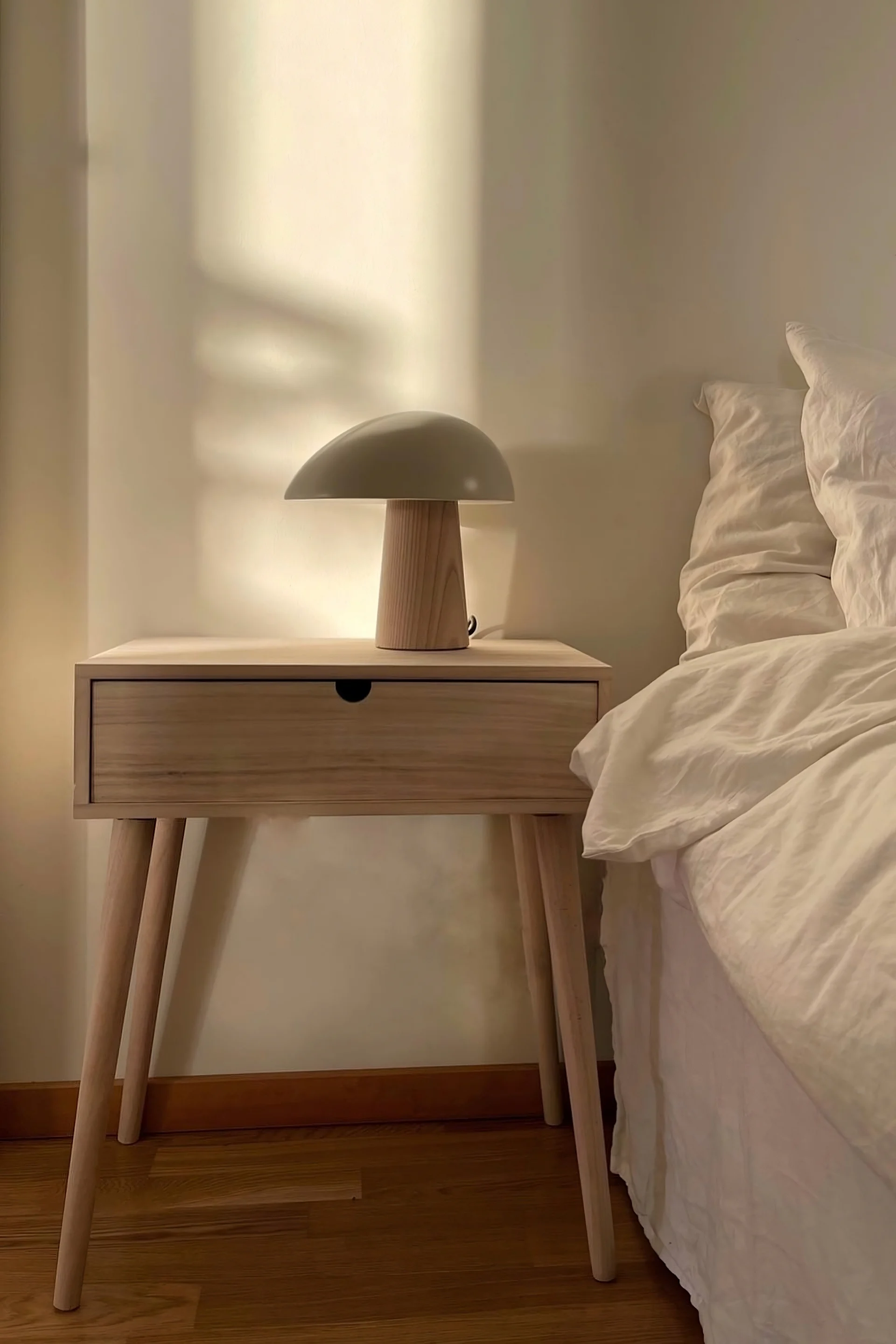 For Feng Shui in the bedroom, simple furnishings are ideal. @homebyhanna has a simple wooden bedside table next to her bed with a Night Owl table lamp by Fritz Hansen on top.
