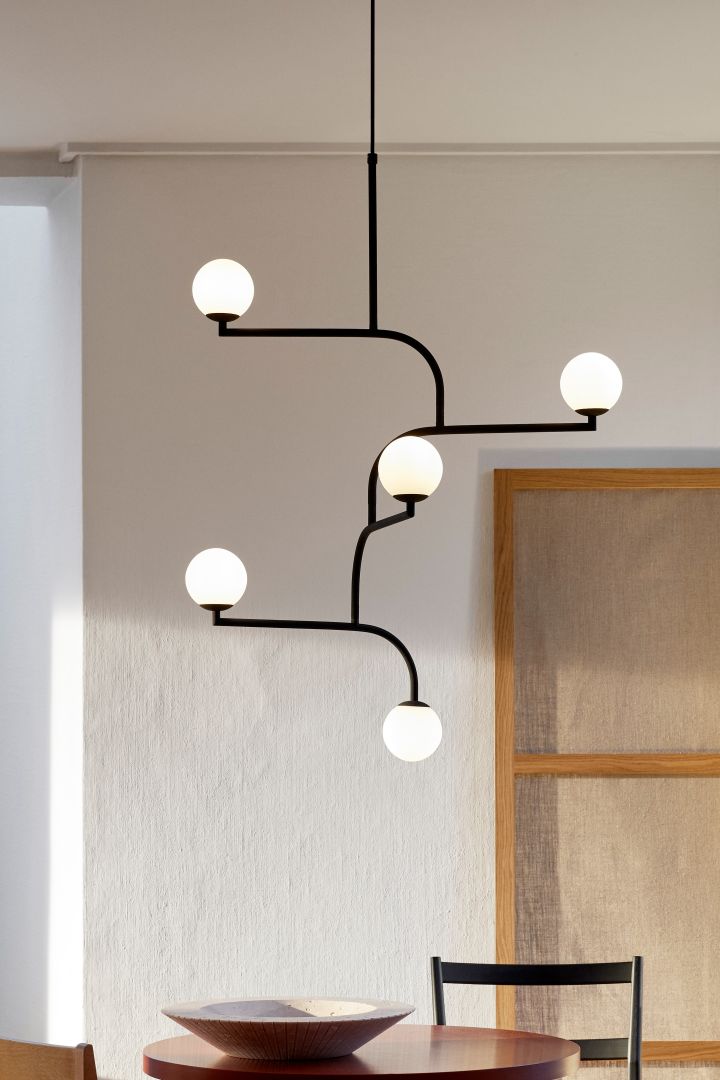 11 stylish ceiling lights to decorate your home with - here you see the Mobile 100 ceiling light from Pholc, hanging over a dining table. 