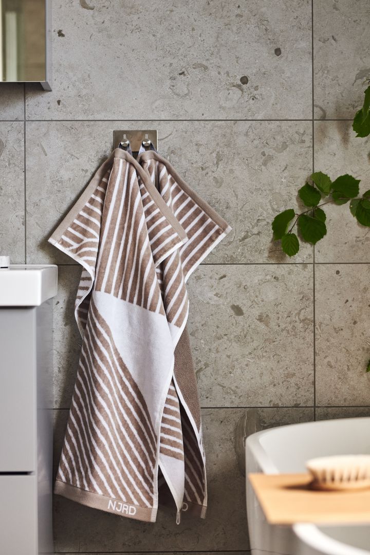 Create a spa feeling in the bathroom with NJRD Stripes towel in beige - the most relaxing autumn interior design trends 2021.