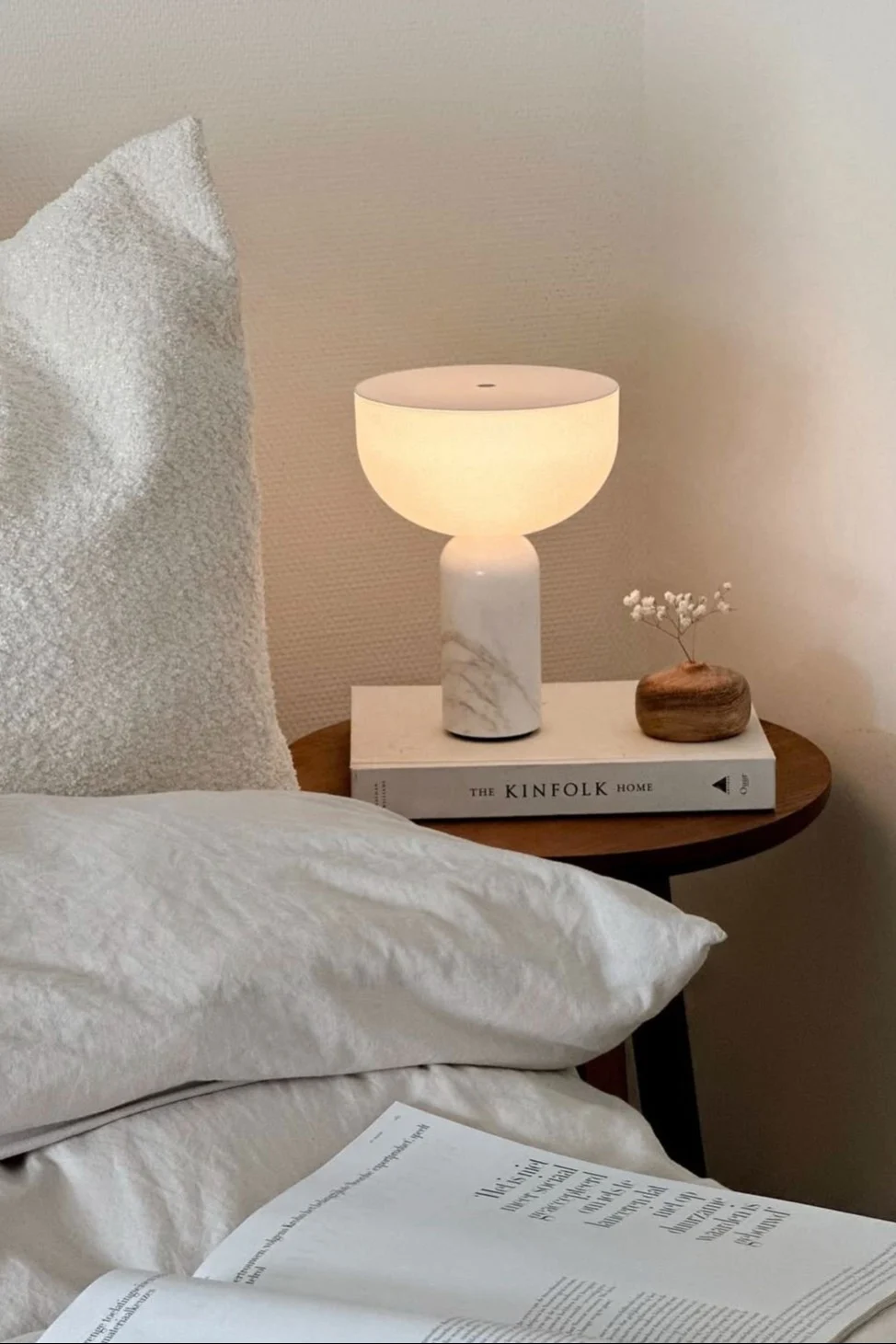 Next to the bed by @wonen.met.lef stands a stool with the Kizu table lamp by New Works.