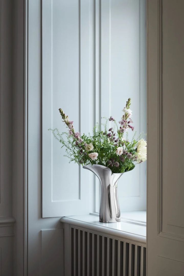 The Bloom Botanica vase in metallic finish stands in a window with a beautiful Valentine's day bouquet. 