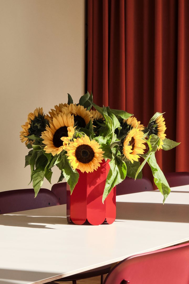 Red elements are among the strongest tones in the Scandinavian interior design trends in 2024 and here they are represented in the playful Arcs vase in red from HAY, filled with sunflowers. 