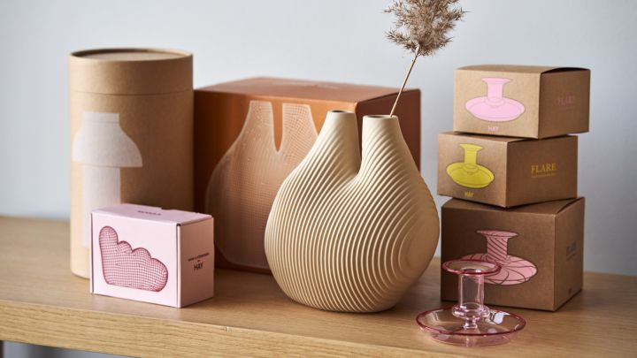 The W&S chamber vase in beige from HAY surrounded by the colourful product boxes.