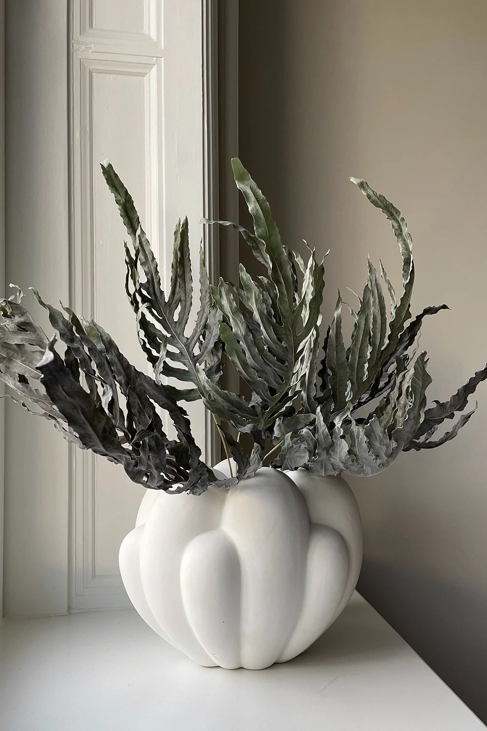 One of the spring 2024 interior design trends is playful minimalism, where a more neutral colour scheme can still create a vibrant home using exciting shapes, textures and materials. Here the Bloom vase in white from 101 Copenhagen.